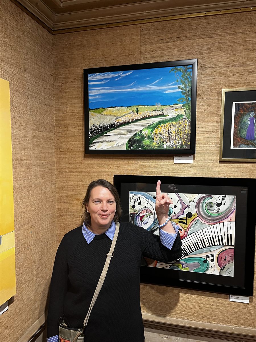 Uta Raina with her painting at a gallery exhibition.